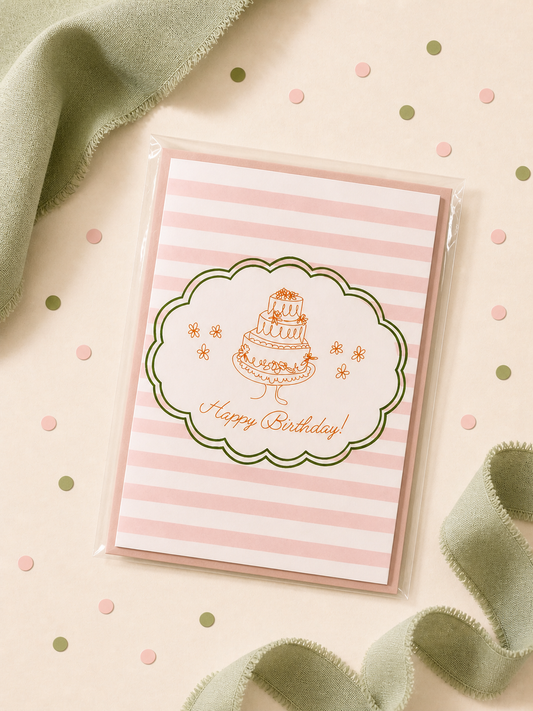 Birthday card with cake illustration on a striped background, surrounded by green fabric and polka dots.