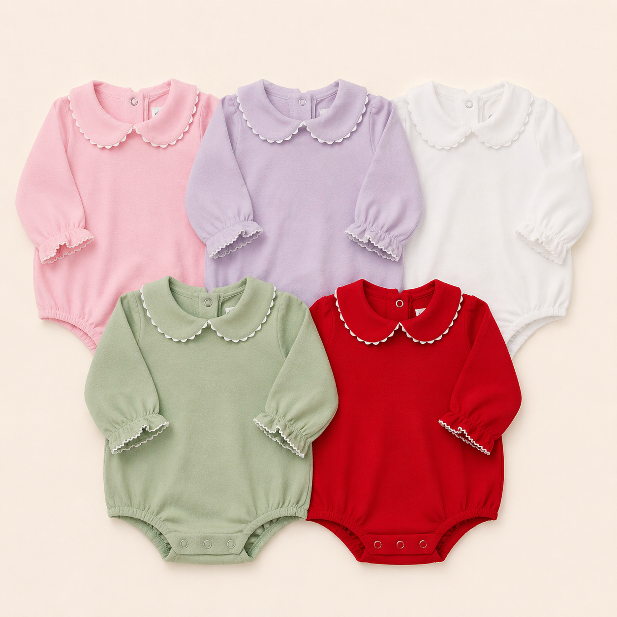 Five baby rompers in pink, purple, white, green, and red on a beige background.