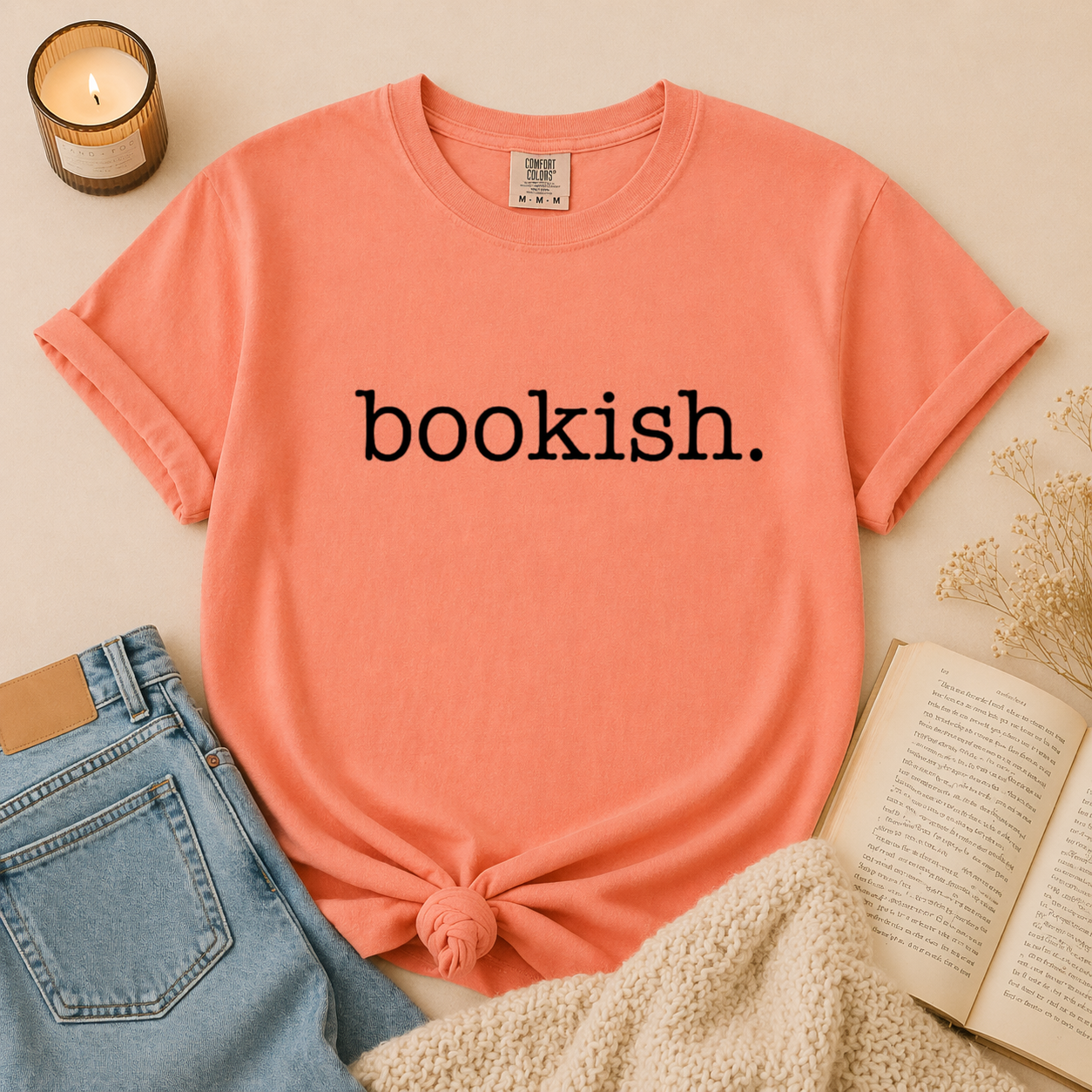 Coral bookish t-shirt with minimalist typewriter style text worn in lifestyle photo