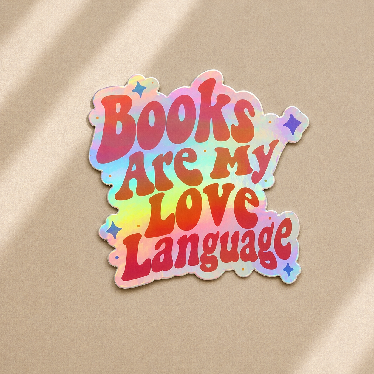holographic pink sticker with 'Books Are My Love Language' text on a beige background