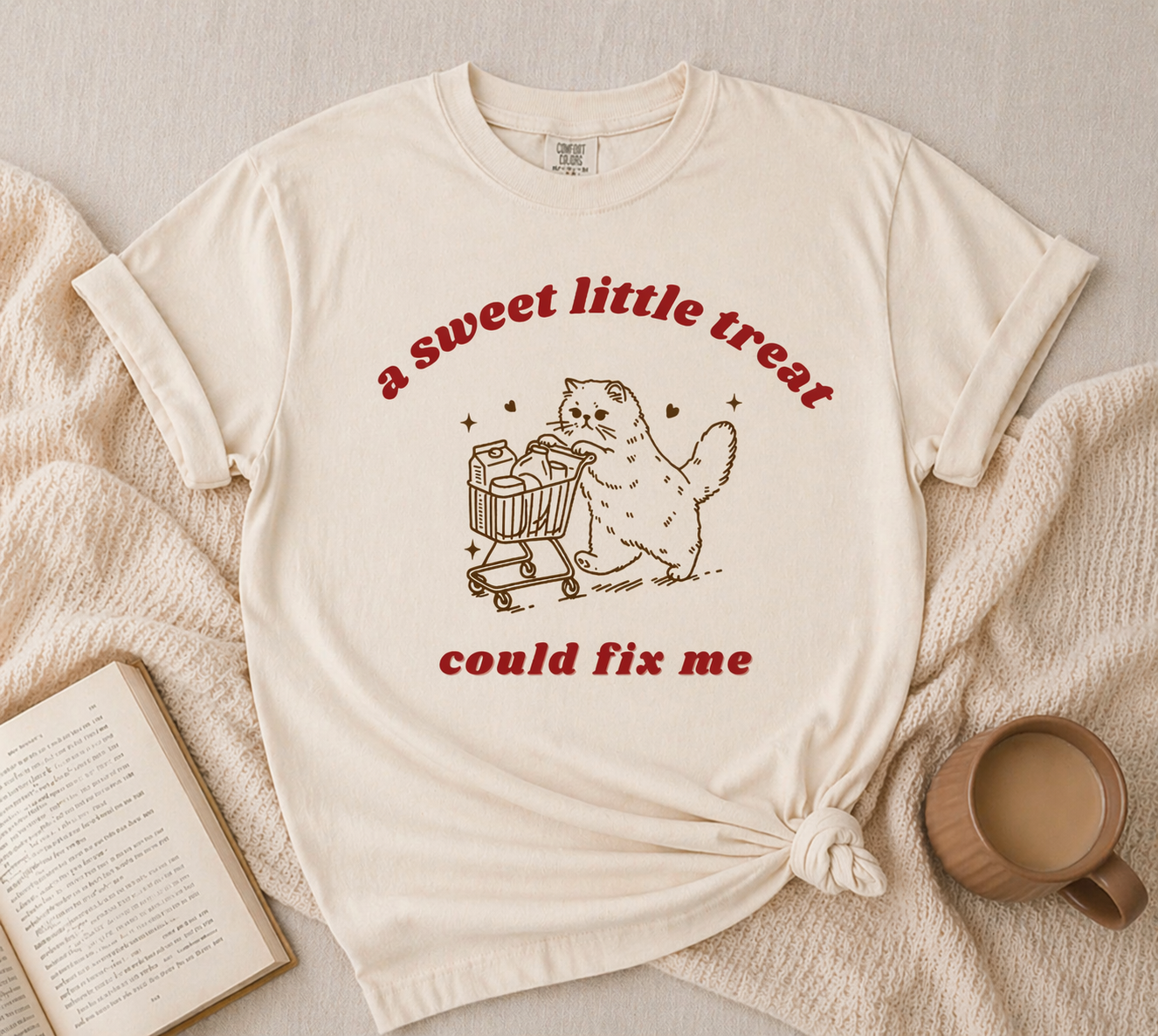 cream graphic t-shirt with cute cat pushing shopping cart sweet treat design