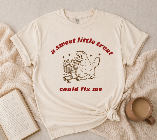 cream graphic t-shirt with cute cat pushing shopping cart sweet treat design