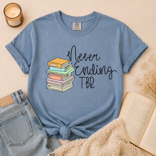 Blue book lover t-shirt with never ending TBR design and stacked books graphic worn in lifestyle photo