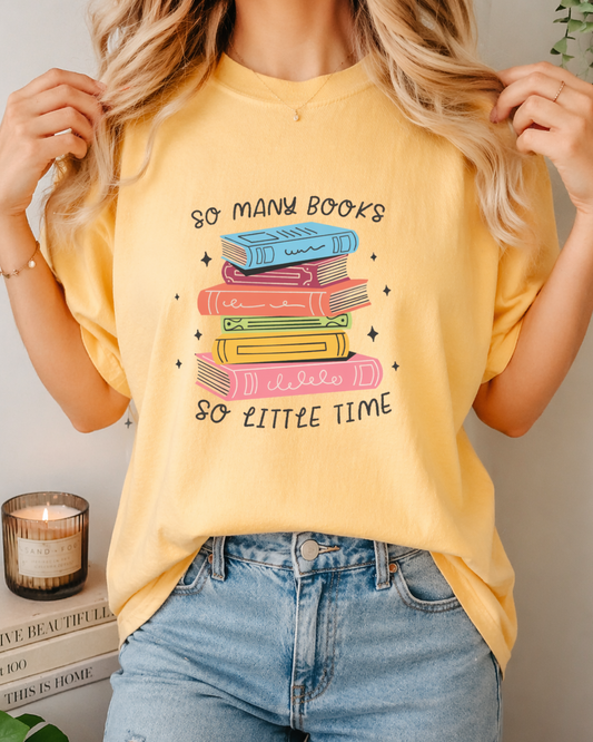 Person wearing a yellow t-shirt with a book-themed design, standing in a casual setting.